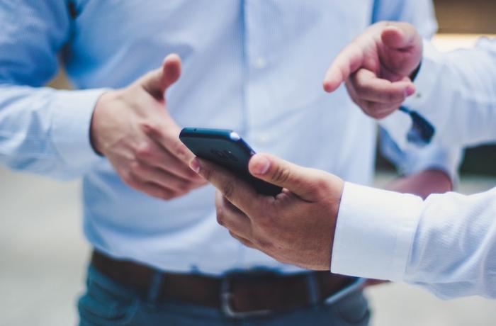 2 hommes regardant une appli sur mobile